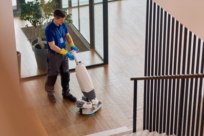 Cleaner vacuuming a commercial lounge area